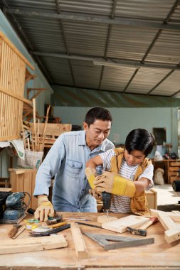 Baba ilk kez elektrikli alet le odun sondaj ı kontrol onun preteen oğlu kontrol