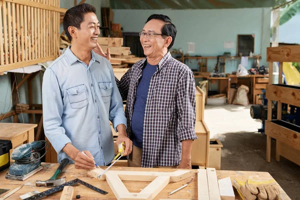 ベトナムの高齢者と彼の大人の息子は 小さなガレージワークショップで家具を作ります — ストック写真