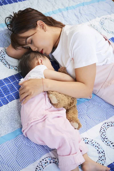 かなり若いベトナムの女性と彼女のかわいい赤ちゃんは大きなベッドで眠って感じました — ストック写真
