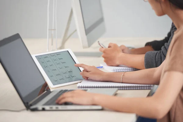 노트북 키보드에 타이핑의 자르기 측면보기 책상에 단어의 목록과 태블릿 화면을 — 스톡 사진