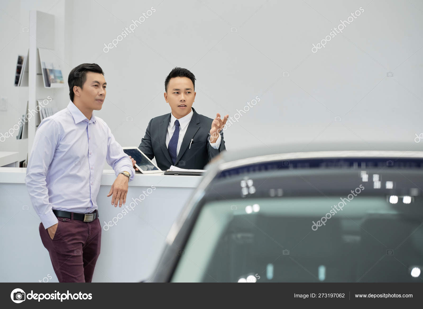 Young Vietnamese Car Dealership Worker Showing Vehicles Wealthy