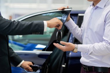 Müşteriye araba anahtarları veren bayilik satıcıyakın çekim görüntüsü