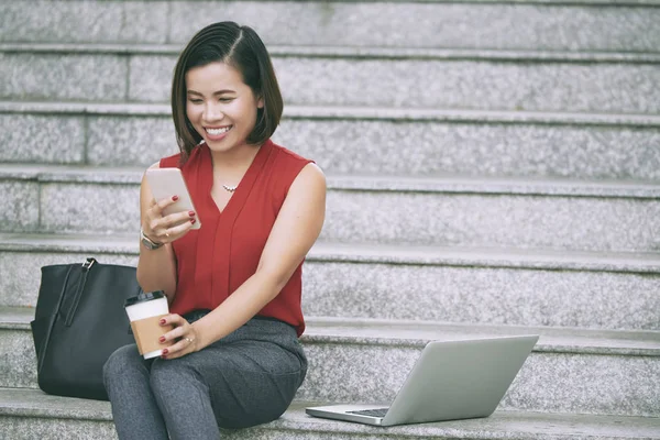 Happy Asian Woman Communicating Online Using Mobile Phone While Drinking — Stock Photo, Image