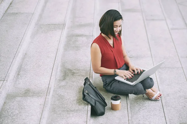 Усміхнена Молода Жінка Сидить Сходах Міста Працює Інтернеті Друкуючи Ноутбуці — стокове фото