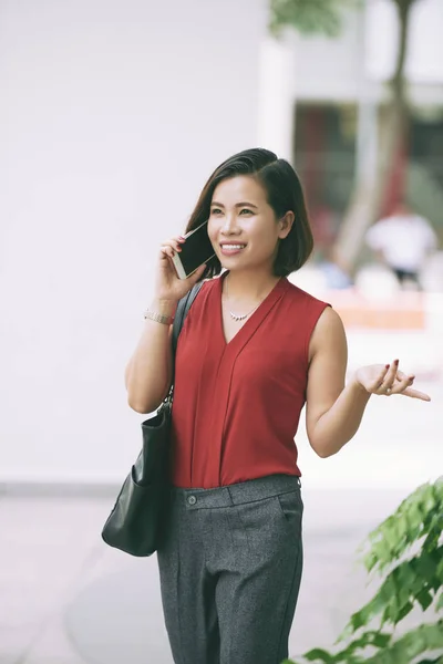 美しいアジアのマネージャーは 彼女のスマートフォンで話し ジェスチャー通りに沿って歩いて — ストック写真