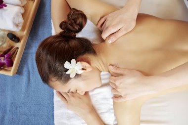 Genç Asyalı kadın güzellik salonunda sırt masajı yapıyor, yukarıdan görünüyor. 