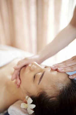 Uzman yağlar ve serum ile gençleştirici yüz masajı yapıyor 