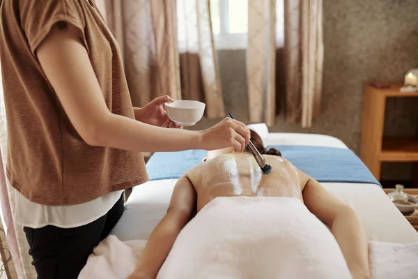 Cosmetólogo Usando Cepillo Con Cerdas Naturales Aplicar Tratamiento Piel Espalda — Foto de Stock