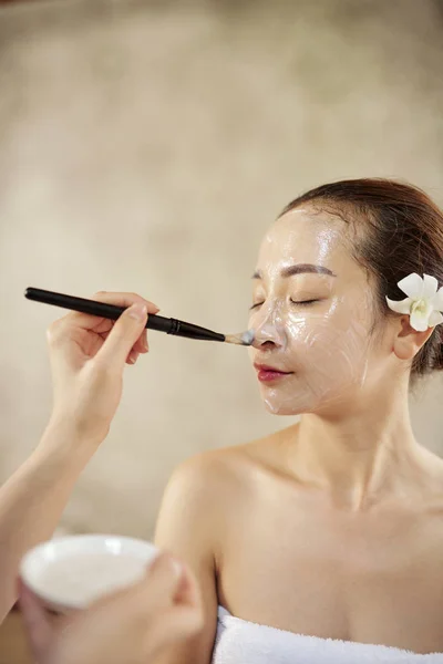Cosmetólogo Usando Cepillo Aplicar Mascarilla Hidratante Cara Mujer Bonita — Foto de Stock