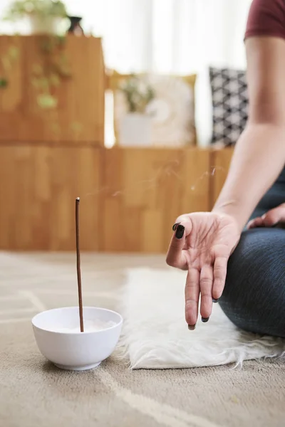 Meditating woman using aroma stick when meditating and practicing yoga at home