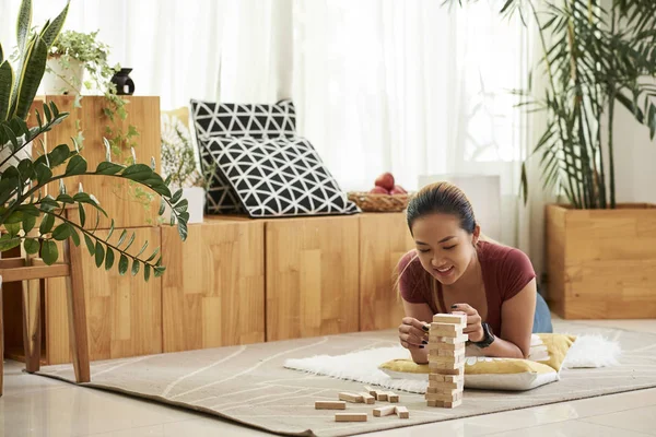 Молодая Азиатка Лежит Полу Играет Деревянными Блоками — стоковое фото