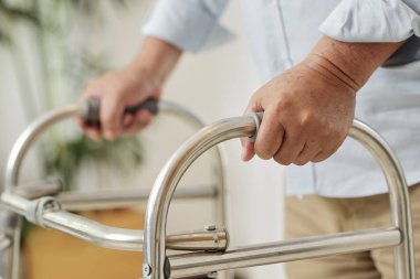 Walker'ın yardımıyla hareket eden üst düzey bir adamın yakın çekim, o ameliyat sonrası rehabilitasyon geçiyor