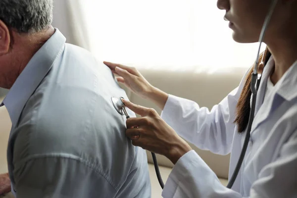 Female Doctor Examining Her Senior Patient Stethoscope While Sitting Back — Stock Photo, Image