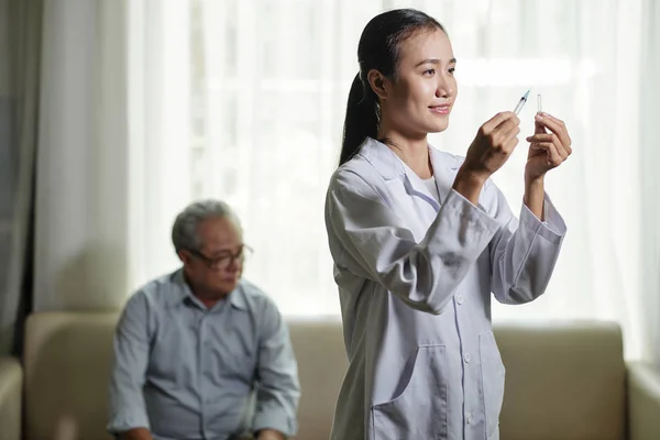 Asiático Jovem Enfermeira Casaco Branco Preparando Vacina Para Homem Idoso — Fotografia de Stock