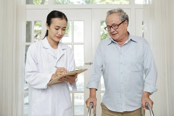 Asiatico Giovane Medico Bianco Cappotto Piedi Riempire Scheda Medica Con — Foto Stock