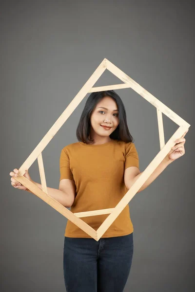 年轻笑容满面的亚洲女人拿着木制相框摆姿势 — 图库照片