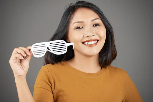 面对亚洲少女与白色牙齿的笑容采取提供她的快门眼镜和看相机 — 图库照片