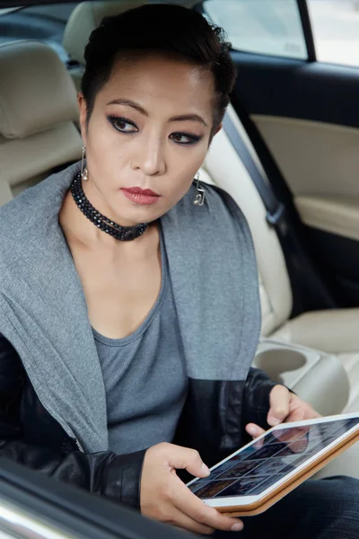 タクシーに乗るとき インターネットを閲覧美しいスタイリッシュなアジアの女性 — ストック写真