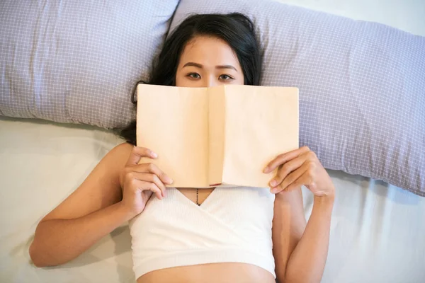 Porträtt Asiatisk Ung Kvinna Liggande Sängen Med Bok Tittar Kamera — Stockfoto