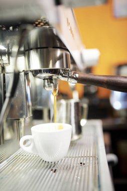 Kahve dükkanında kahve makinesinden dere siyah sıcak kahve altında duran beyaz fincan yakın çekim