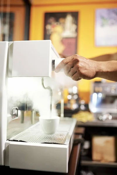 レストランのコーヒーマシンでコーヒードリンクを作るプロセスを制御する男のクローズアップ — ストック写真
