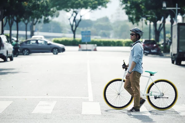 过马路时 男人在自行车旁边行走 — 图库照片