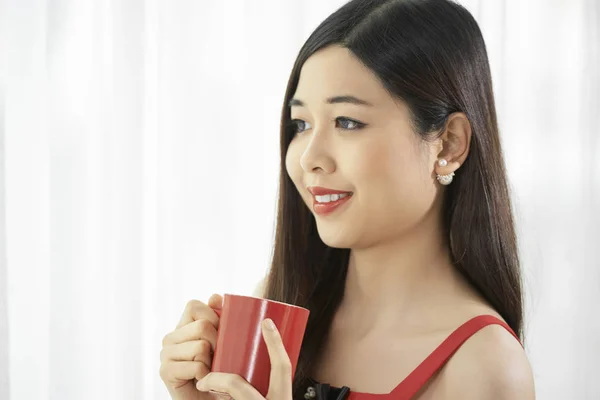 Asyalı Genç Kadın Ayakta Kahve Bardağı Tutarak Gülümseyerek Uzağa Bakıyor — Stok fotoğraf