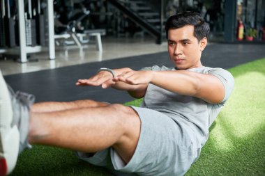 Yakışıklı genç Vietnamlı adam spor salonunda onun abs için zor egzersiz yapıyor