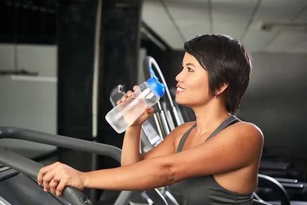 ジムで運動する際に淡水を飲む美しい笑顔フィット女性 — ストック写真