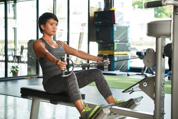 Concentrado Joven Asiática Mujer Haciendo Ejercicio Fila Máquina Gimnasio — Foto de Stock