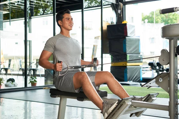 Cheerful Young Asian Man Doing Exercises Row Machine — Stock Photo, Image