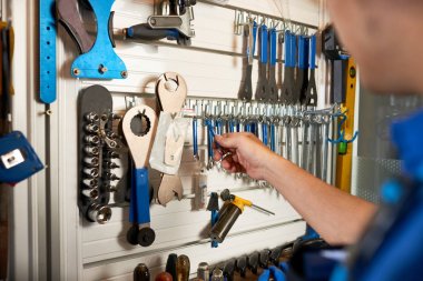 Atölyede tamircinin ayakta durması ve enstrümanlarını duvara asmak için yakın çekim