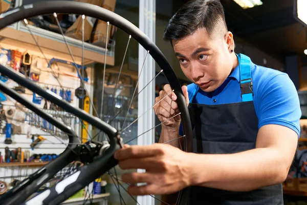 Seriöser Asiatischer Reparateur Vorfeld Der Das Rad Der Werkstatt Repariert — Stockfoto