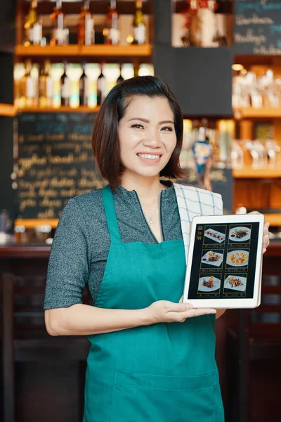 快乐漂亮的女服务员显示平板电脑与菜单在屏幕上 — 图库照片