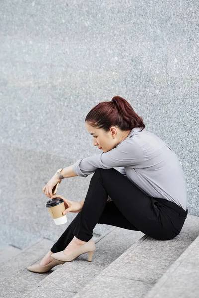 漂亮的年轻亚洲妇女深在思想休息的步骤与一杯带走咖啡 — 图库照片