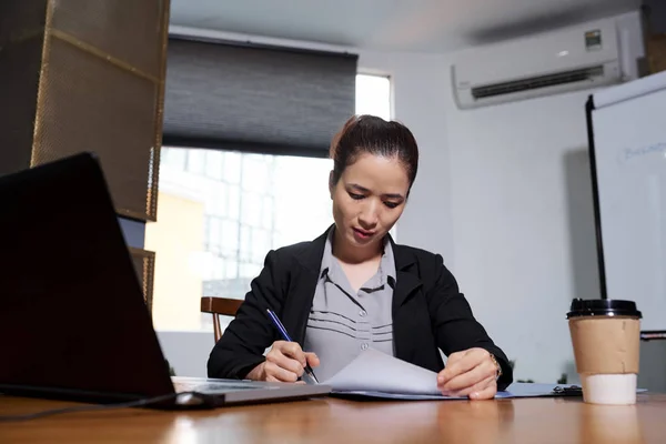 若いベトナムのビジネス女性は彼女のオフィステーブルで契約書を読んで署名 — ストック写真