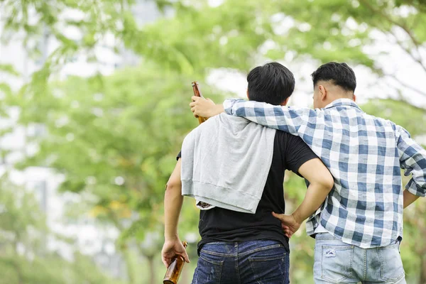 Vista Posteriore Due Amici Che Abbracciano Bevono Birra Mentre Passeggiano — Foto Stock