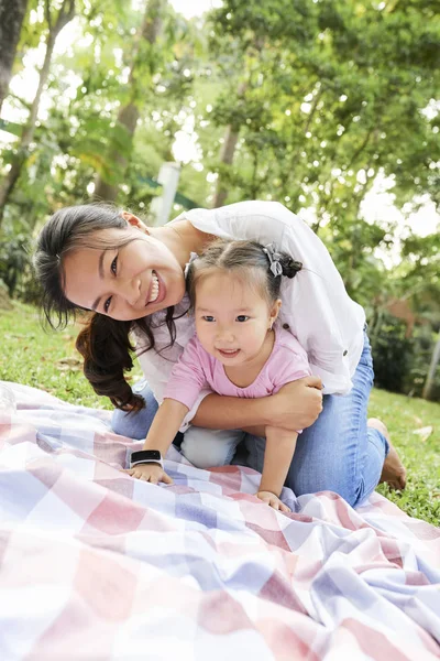 快乐的越南母亲和女儿在城市公园的毯子上玩耍 — 图库照片