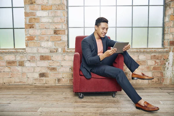 Guapo Sonriente Joven Empresario Elegante Sentado Silla Leyendo Artículo Sobre —  Fotos de Stock