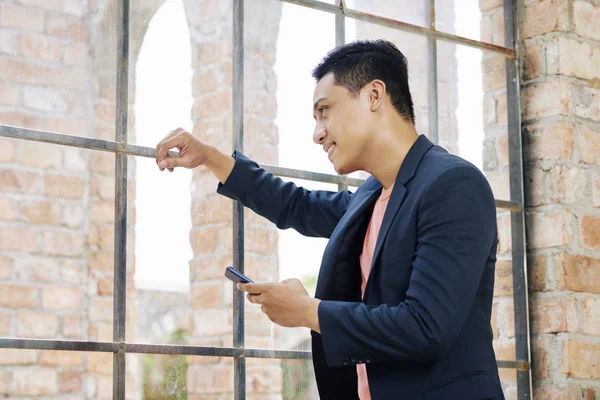 Positieve Jonge Vietnamese Business Executive Met Smartphone Hand Kijken Door — Stockfoto