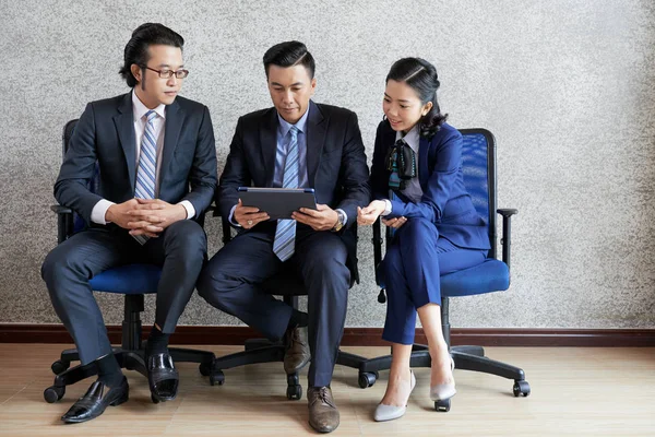 一群亚洲商界人士坐在椅子上 一起看着数字平板电脑上的在线演示 — 图库照片