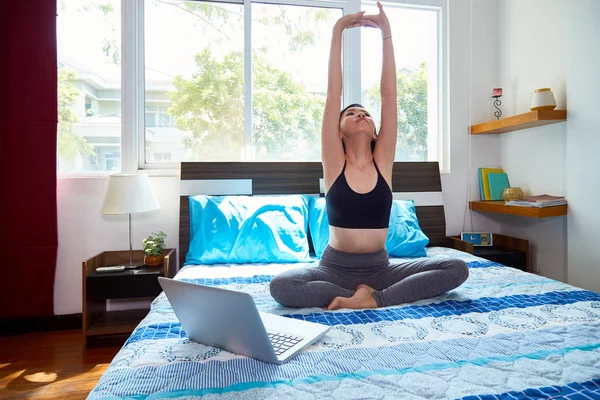 Young Woman Sitting Bed Front Laptop Doing Stretching Exercises Bedroom — ストック写真