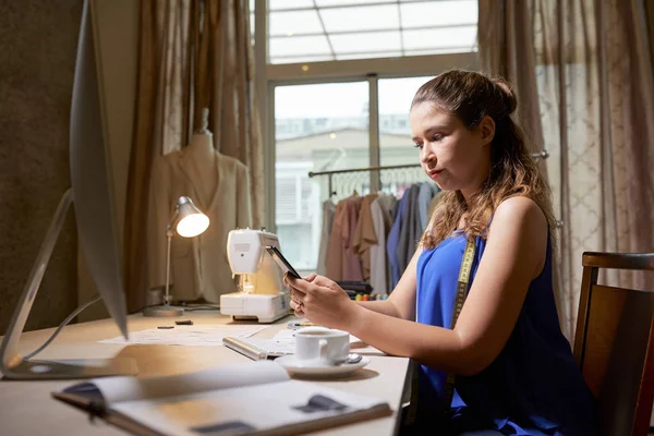 Jovem Empresária Séria Sentada Mesa Usando Telefone Celular Enquanto Trabalhava — Fotografia de Stock