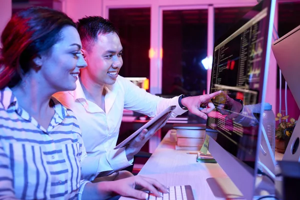 Uśmiechnięty Młody Biznesmen Wskazując Monitorze Komputerowym Omawiając Program Komputerowy Businesswoman — Zdjęcie stockowe
