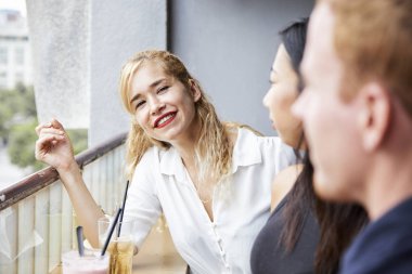 Güzel genç sarışın kadın arkadaşları ile kafede dinleniyor