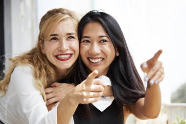 Neşeli güzel genç muti-etnik arkadaşlar ilginç bir şey işaret