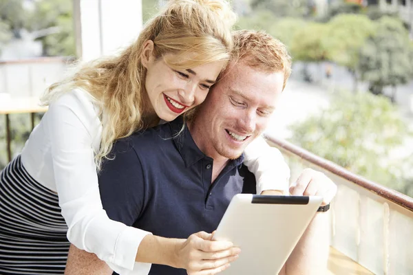 愉快的年轻夫妇在预订酒店或在线购物时查看平板电脑屏幕 — 图库照片