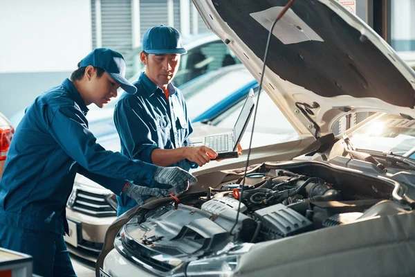 Mechanika Przy Użyciu Laptopa Podczas Sprawdzania Samochodu Garażu — Zdjęcie stockowe