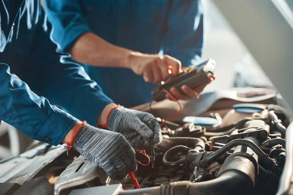 Mechanika Przy Użyciu Wielu Liczników Podczas Sprawdzania Pracy Silnika Samochodowego — Zdjęcie stockowe