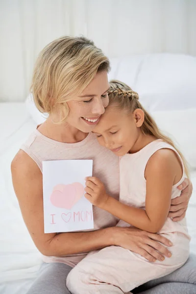 Smiling Happy Girl Hugging Her Mother Giving Her Greeting Card — Stock Photo, Image